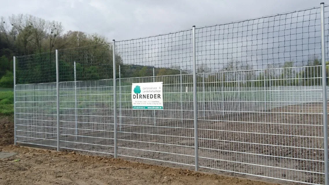 Hoher verzinkter Gitterzaun mit dem Dirneder-Firmenschild